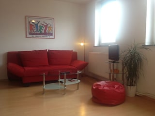 Wohnbereich mit Schlafsofa und Flat TV