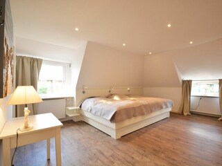 Das Bett im großzügigen fünften Schlafzimmer bietet Platz für drei Personen.