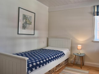 ... sowie dieses Schlafzimmer mit Einzelbett.