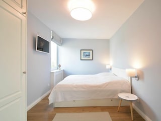 Das Schlafzimmer verfügt über zwei Fenster und einen Flachbild-TV.