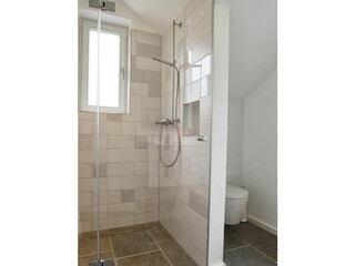 Das Badezimmer mit bodengleicher Dusche befindet sich direkt neben dem Schlafzimmer.