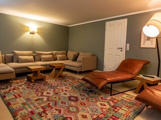 Gegenüber der Sauna befindet sich ein zweites Zimmer zum Entspannen. Hier befindet sich eine Musi...