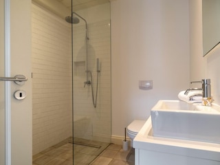 Im Erdgeschoss befindet sich ebenfalls ein Gäste-WC mit bodengleicher Dusche.