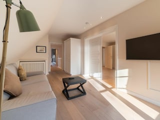 Im Obergeschoss gibt es neben dem Schlafzimmer ein weiteres gemütliches Fernsehzimmer.