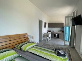 Wohnzimmer mit Doppelbett und Kochecke