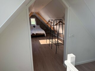 das Schlafzimmer im Obergeschoss mit einem Kleiderablag