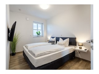 Schlafzimmer im Erdgeschoss mit Boxspringbett