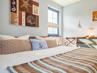 Schlafzimmer mit Doppelbett und Kommode