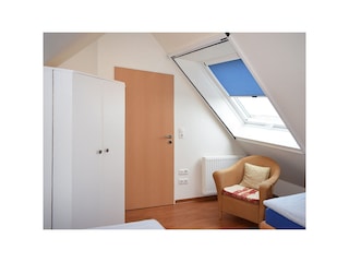Schlafzimmer mit Schrank und Sessel