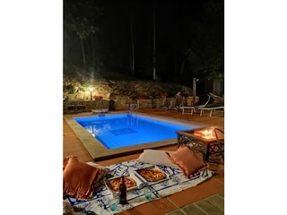 Outdoor fireplace with lit up pool