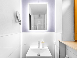 Bad mit beleuchtetem Spiegel