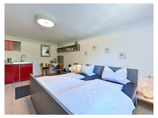 Schlafzimmer mit Doppelbett und Kochnische im 1.Stock