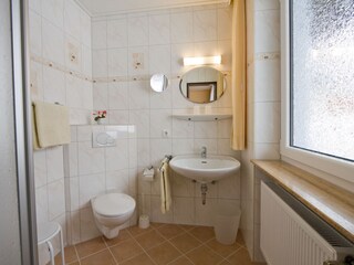 Das hell und freundlich eingerichtete Badezimmer