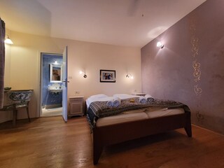 Sleeping room with double bed and small Bathroom