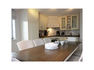 Der große Esstisch, im Hintergrund die Küche