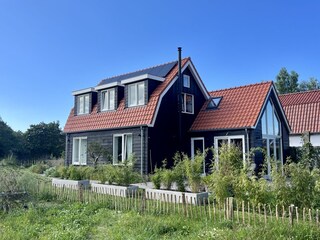 Ein charmantes Haus mit einer grünen Landschaft und ein