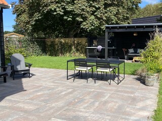 einem grünen Garten und einer stimmungsvollen Terrasse.
