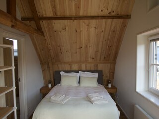 Cosy wooden interior and comfortable made beds.