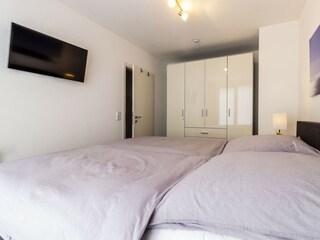 Zweites Schlafzimmer mit Boxspringbett und TV