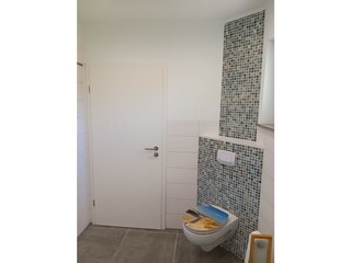 Helles Duschbad mit Toilette und Handtuchtrockner