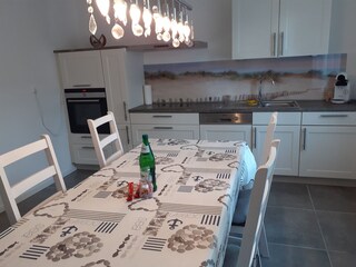 Moderne, gut ausgestatte Küche mit großem Esstisch