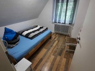 Schlafzimmer mit 140x200cm Einzel Bett u. Fliegengitter