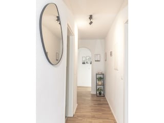 Großer Flur mit Garderobe und kleinem Wandspiegel.