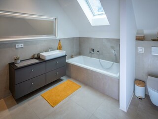 Badezimmer mit Badewanne und WC