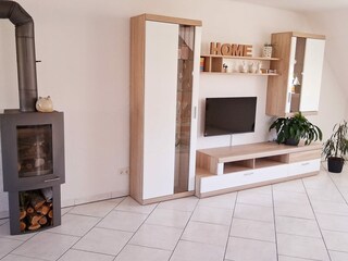 Wohnzimmer mit TV und Kaminofen