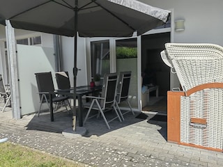 Terrasse mit Sonnenschutz und kleinem Gartenanteil