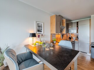 erhöhter Esstisch mit edlen Lederstühlen