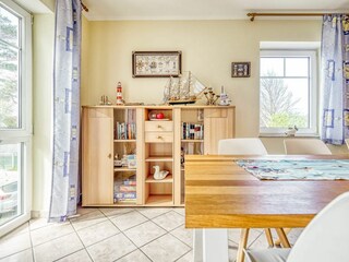 Wohnzimmer mit Esstisch, Bestuhlung und offener Küche