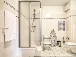 Badezimmer mit Dusche, WC, Spiegel und Waschbecken