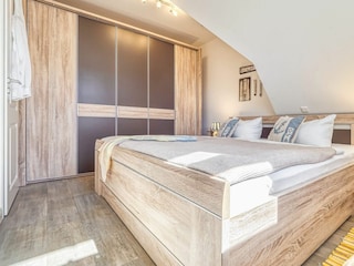 Schlafzimmer mit Doppelbett und Kleiderschrank
