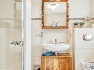 Badezimmer mit Spiegel, Waschbecken und WC