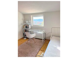 Schlafzimmer mit Zusatzbett und Arbeitsbereich