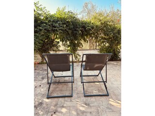 Liegestühle im schattigen privaten Garten