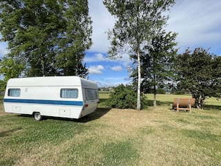 Vintage-Camper mit Burgblick neben Waldsofa