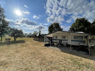 Wohnwagen mit Außenküche und Sitzgelegenheit