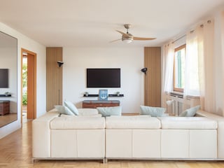 Offenes Wohnzimmer mit Ledersofa und TV