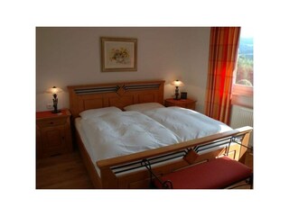 Schlafzimmer mit Doppelbett und Außenrolläden