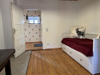 Doppelbett (ausziebahr) im kleinen Schlafzimmer.