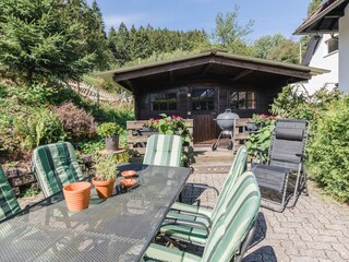 Terrasse mit Grill und großem Sonnenschirm