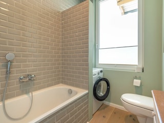 Badezimmer mit Waschmaschine und Badewanne