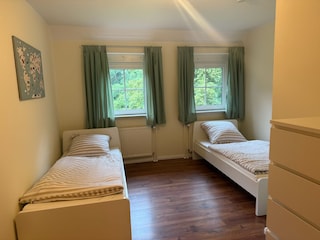 Zimmer mit Einzelbetten und Kommode