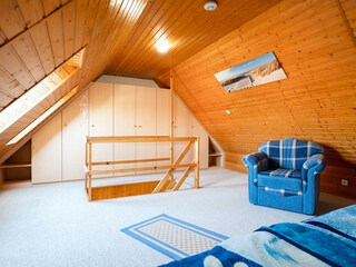 zweites Schlafzimmer mit Kleiderschrank und Sessel