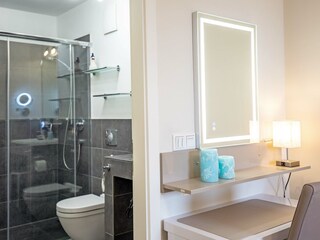Bad 1 en Suite und Kosmetiktisch im Schlafzimmer