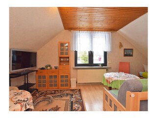 Living area with a single bed on the right (not visible in the photo).