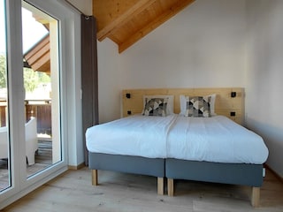 Schlafzimmer 1 mit Komfortsbetten und Zugang zum Balkon