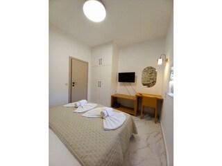 Schlafzimmer mit Doppelbett und TV